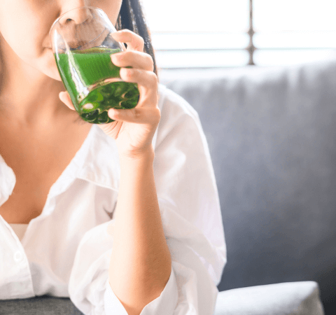 Woman drinking green drink